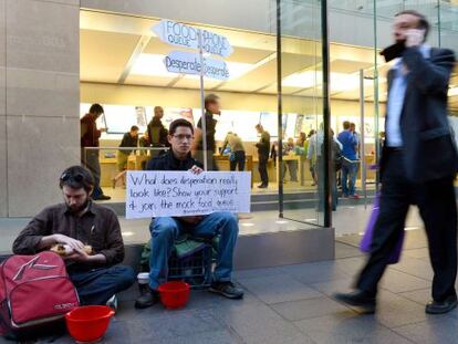 Protesta contra el consumismo en una tienda de Apple en Sidney. A un lado la cola del iPhone, al otro, los que pasan hambre.