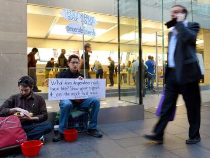 Protestando contra el consumismo  en una tienda de Apple en Sidney. A un lado la cola del iPhone, al otro los que pasan hambre. 