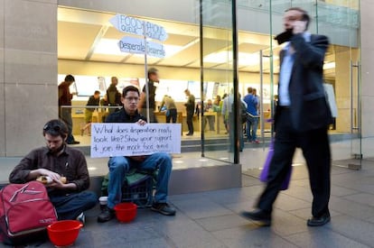 Protesta contra el consumismo en una tienda de Apple en Sidney. A un lado la cola del iPhone, al otro, los que pasan hambre.