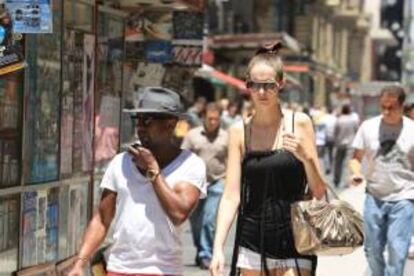 Dos jóvenes caminan bajo el sol en una calle de Buenos Aires (Argentina). EFE/Archivo