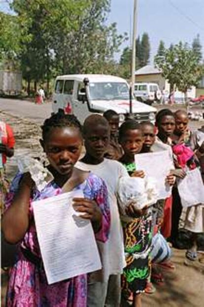 Niños ruandeses esperan a un equipo de Cruz Roja  para intentar reencontrarse con sus familias. En la mano sostienen sus expedientes.