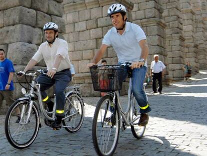 Perico Delgado (derecha) va en bicicleta con el alcalde de Segovia, Pedro Arahuetes.