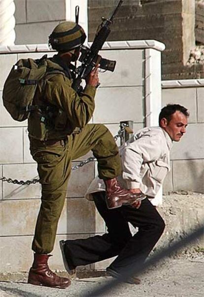 Un soldado israelí y un detenido palestino, ayer en Nablus (Cisjordania).