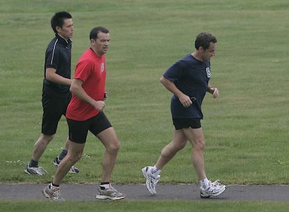 El presidente francés, Nicolas Sarkozy, corre seguido por sus guardaespaldas en un campo de golf en Toyako.