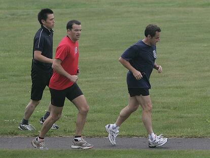 El presidente francés, Nicolas Sarkozy, corre seguido por sus guardaespaldas en un campo de golf en Toyako.