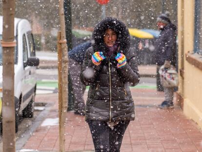 Una mujer se protege de la nieve, este lunes en Teruel, donde la mínima fue de -6°.