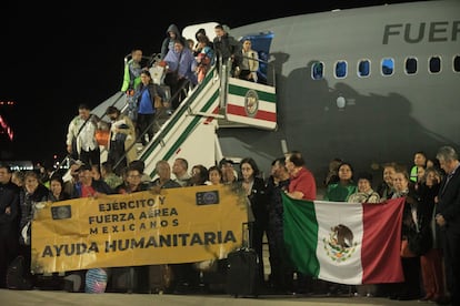 Algunos de los 143 pasajeros del primer vuelo de repatriación posan frente al avión, el pasado miércoles 11 de octubre.