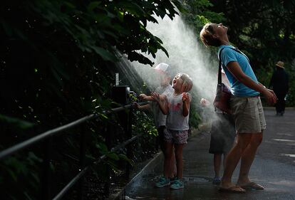 Visitantes disfrutan del agua pulverizada mientras visitan el Parque Zoológico Nacional de Smithsonian, en Washington DC (Estados Unidos).