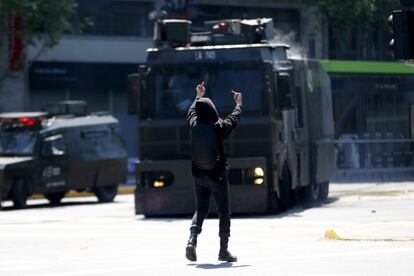 Un manifestante estudiantil hace gestos a la policía antidisturbios durante una protesta para exigir cambios en el sistema educativo en la ciudad de Santiago, Chile.