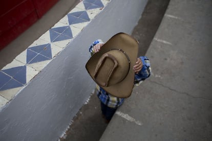 Un niño se acomoda su sombrero de vaquero antes de que comience la charreada en la Asociación Nacional de Charros. Fernando Medellín Leal, que lleva practicando la charrería desde hace 30 años, afirma que la tradición es transmitida de abuelos a padres, y de padres a hijos.