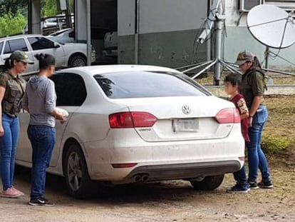 La mujer argentina secuestrada durante 32 años, con sudadera de color gris, entra en un coche de la policía junto a su hijo de 9 años.