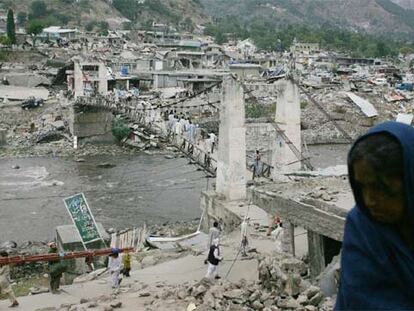 Una mujer, ante el puente que conecta las dos orillas de la ciudad paquistaní de Balakot, arrasada durante el terremoto del sábado.