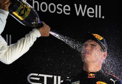 Lewis Hamilton, a la derecha, lanza champán a Max Verstappen.