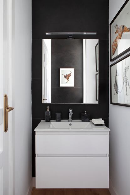 Detalle de uno de los baños de la casa, con la sencillez y el blanco y negro como señas de identidad. En las paredes, obras del artista Rupert Shrive.