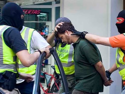 Guardias civiles introducen en un coche al supuesto grapo Israel Clemente a principios del pasado junio tras registrar un piso en Barcelona.