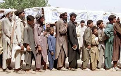 Refugiados afganos hacen cola en un centro de distribución de la ONU en un campo situado cerca de Peshawar, en Pakistán.