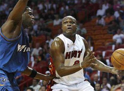 Antoine Walker entra a canasta ante la oposición de Roger Mason