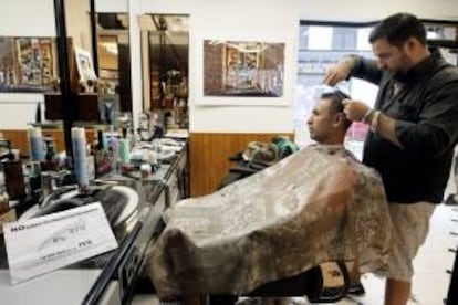 En la imagen el propietario de una barbería, con uno de sus clienes. EFE/Archivo