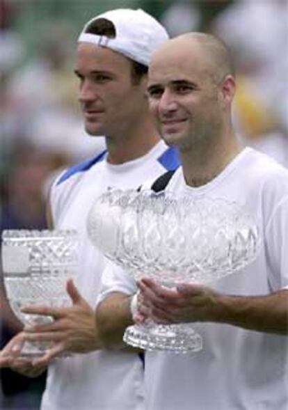 Agassi, en primer plano, y Moyá, con sus respectivos trofeos.