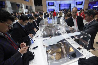 Visitantes en el Mobile World Congress analizan nuevos terminales.