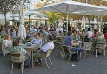 Un gran número de personas disfrutan de la agradable temperatura registrada durante julio en Madrid, en una terraza de la plaza Santa Ana de la capital. EFE/Archivo