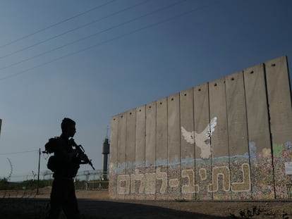 Un soldado Israelí junto a un muro con la leyenda 'Camino a la paz', en la frontera con Gaza, el 17 de noviembre.
