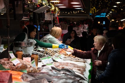Una comerciante cobra a una señora, en el Mercado de la Boquería, en Barcelona.