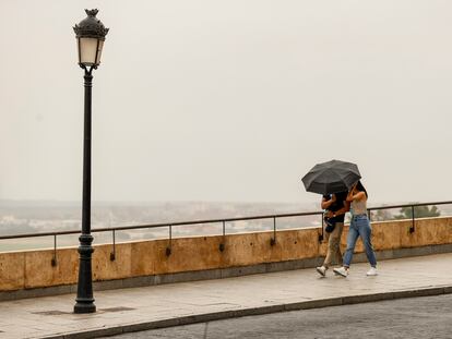 Una pareja se protege de la lluvia, el jueves en Toledo.