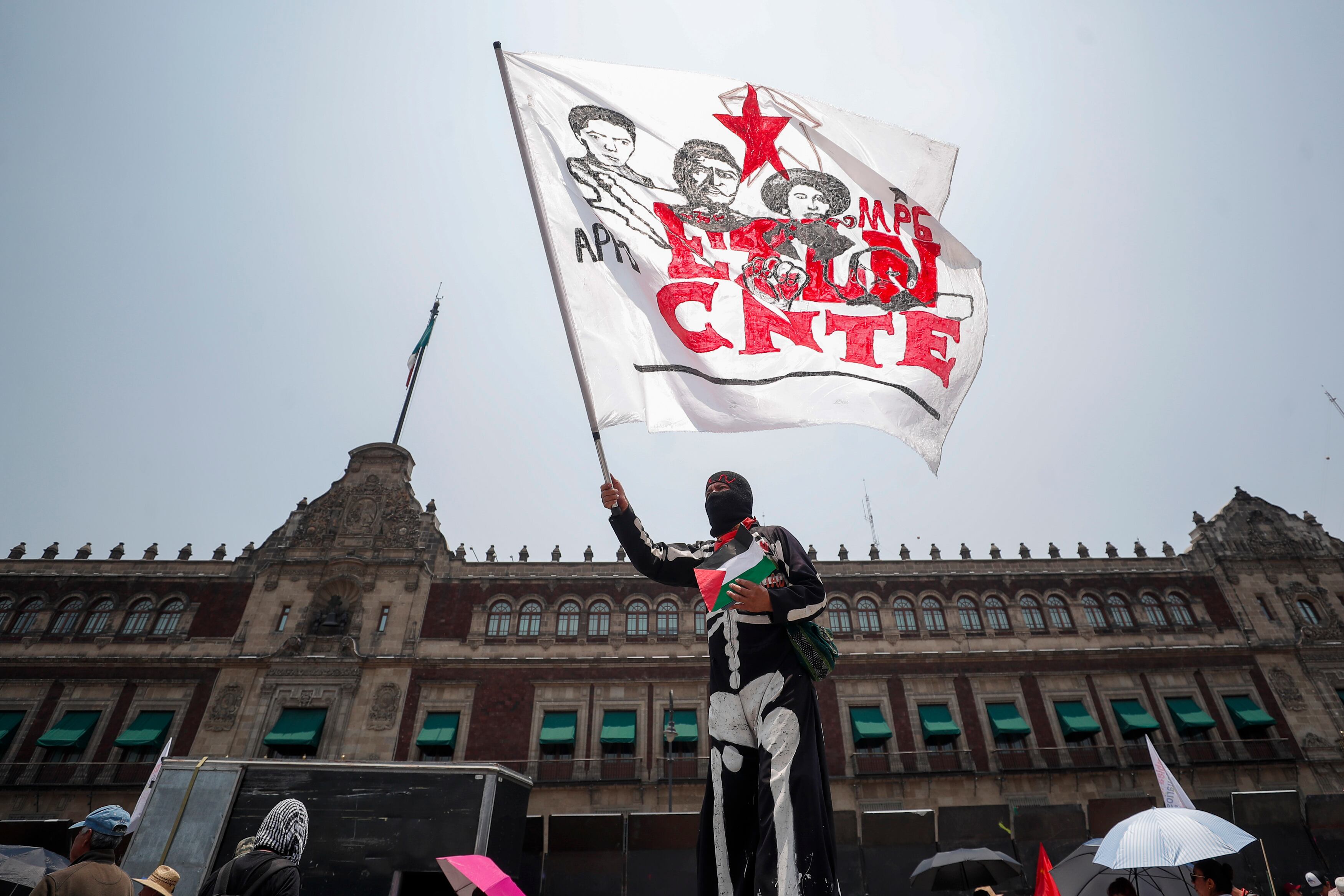 Un manifestante ondea una bandera de la CNTE en el Zócalo de la Ciudad de México este 15 de mayo. 