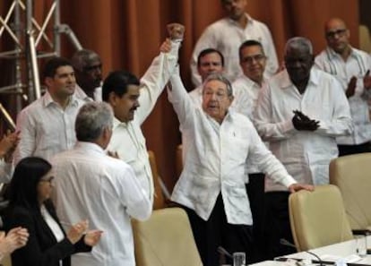 O dirigente cubano Raúl Castro ergue o braço de Nicolás Maduro durante evento em apoio à Venezuela nesta segunda-feira em Havana.