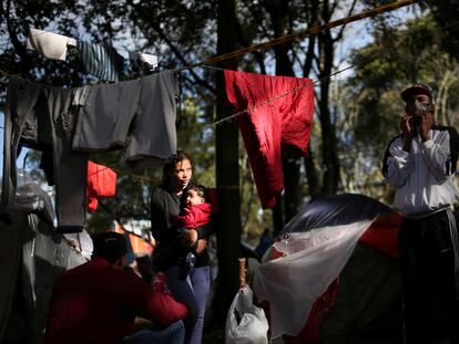 Una migrante venezolana carga a su bebé en un campamento improvisado en las afueras de Bogotá.