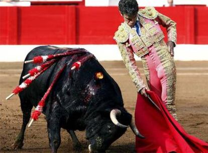 El diestro José Tomás da un pase por bajo al primero de su lote, durante la qunta corrida de abono de la Feria de Santiago, celebrada hoy en Santander.