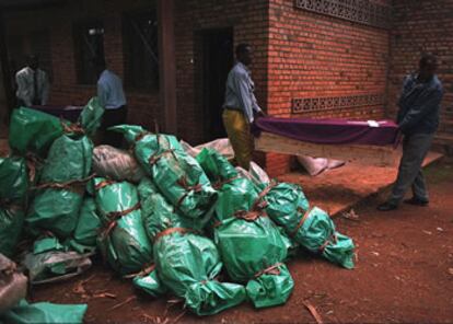 Un hombre pasa ante bolsas que contiene restos, todavía no enterrados, de personas masacradas en el genocidio de Ruanda en el año 1994, en Gikora. 02/04/1998