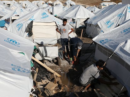 Tres hombres reparan sus tiendas en uno de los campamento para refugiados en la isla griega de Lesbos, el pasado mes de octubre.