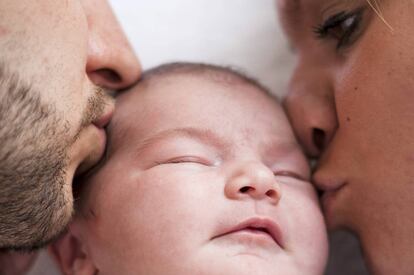 Beb&eacute; durmiendo con los padres al lado. 
 
 