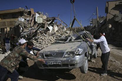 Voluntarios retiran un vehículo aplastado tras la caída de cascotes tras el terremoto en la ciudad de Sarpol-e-Zahab (Irán), el 14 de noviembre de 2017.