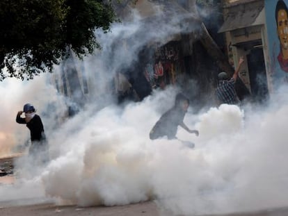 Manifestantes egipcios se enfrentan a la polic&iacute;a junto a la plaza de Tahrir entre el humo de los gases lacrim&oacute;genos. 