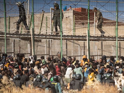 Las fuerzas de seguridad españolas, junto a agentes marroquíes, contienen a un grupo de personas que logró entrar en Melilla el pasado 24 de junio.