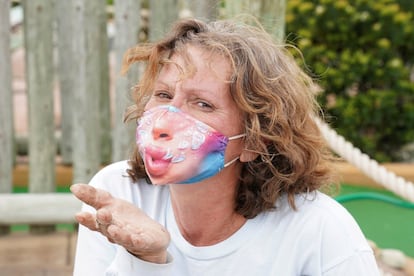 Una mujer muestra su mascarilla para prevenir el coronavirus en Ocean City, Maryland (EE UU).