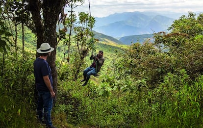 Un turista con Raúl Torres (sentado en el columpio), en la reserva de Yunguilla, en Ecuador.