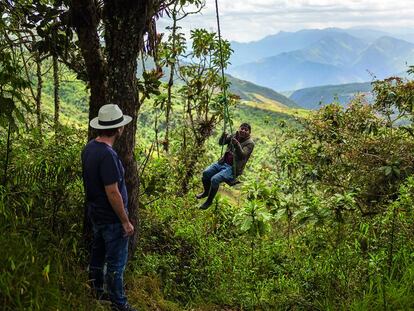 Un turista con Raúl Torres (sentado en el columpio), en la reserva de Yunguilla, en Ecuador.