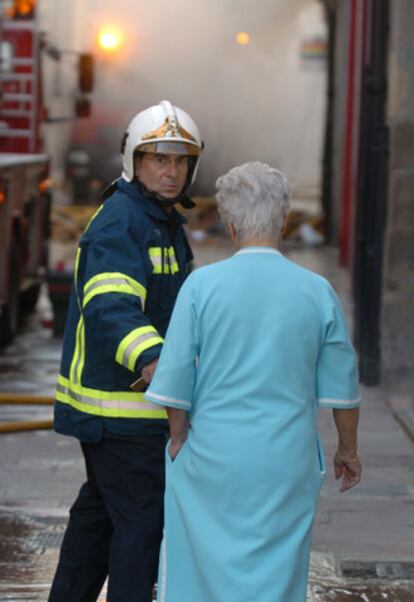 Un bombero tranquiliza a una de las vecinas del inmueble.