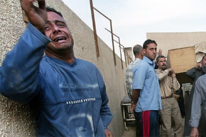 Un hombre llora ante el féretro de su madre, fallecida en el atentado de esta mañana en Bagdad.