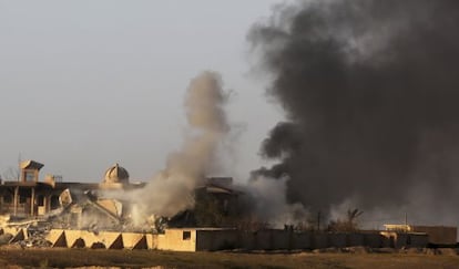 Una columna de humo se eleva en el centro de Tikrit durante los enfrentamientos entre milicianos yihadistas y las fuerzas iraqu&iacute;es.