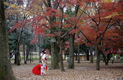 Una turista vestida con un kimono japonés se toma una foto en un paisaje otoñal en un parque de Tokio (Japón), el 4 de diciembre de 2017. 