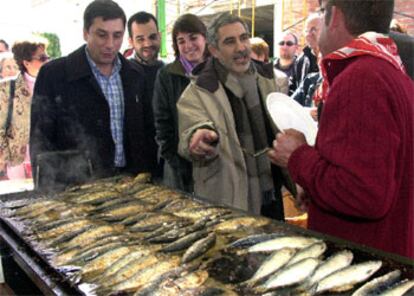 El candidato de IU, junto al coordinador de la formación en Córdoba, en una 'sardinada' para celebrar el día de Andalucía.
