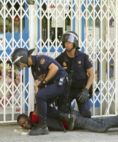 Two police agents arresting a man during the incidents of August 29.
