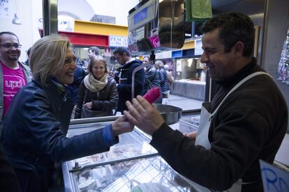 Rosa Díez, entrega una bayeta magenta para limpiar la corrupción a un pescadero, durante su recorrido por el Mercado de Atarazanas de Málaga, el 18 de marzo de 2015.