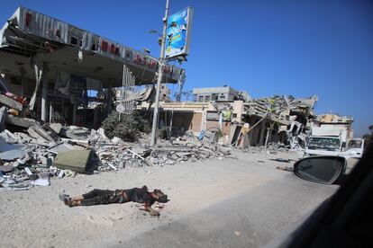 El cuerpo sin vida de un palestino yace en el suelo cerca de un camión acribillado a balazos en el barrio de Tel al-Hawa, en la parte sur de la Ciudad de Gaza.