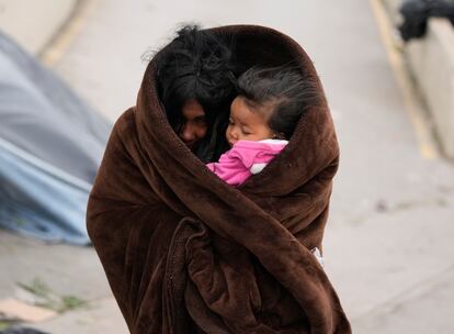 Una migrante venezolna con su hija en brazos se protege del frío en la ciudad de Matamoros (México), el 23 de diciembre de 2022.